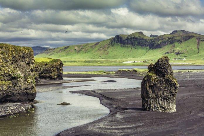 The black sand beach with typical Icelandic mountain landscapes The black sand beach with typical Icelandic mountain landscapes